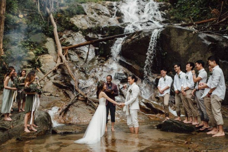 ไอเดียงานแต่งงานที่น้ำตกพร้อมฉากหลังสีเขียวธรรมชาติด้วยต้นไม้และภูเขา พร้อมเต้นรำกลางสายฝนสุดโรแมนติก